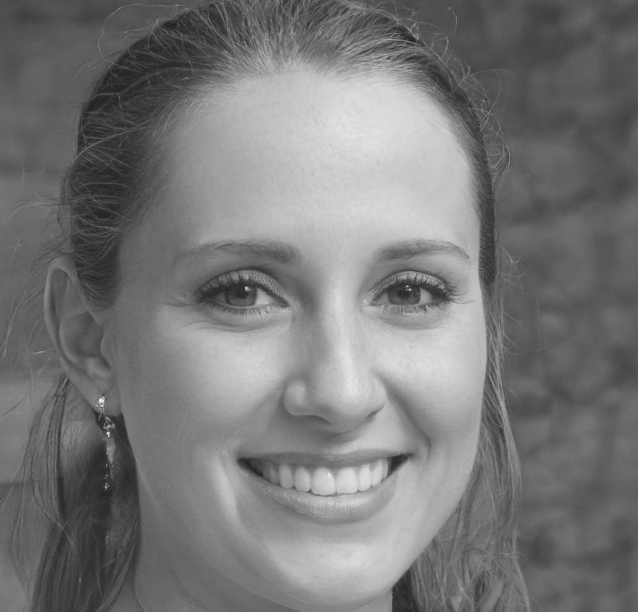 Financial educator reviewing budgeting worksheets and providing personalized guidance to program participants